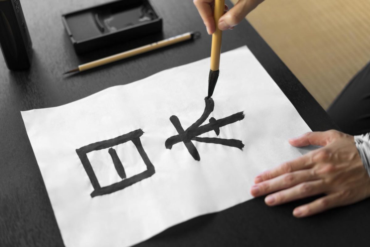 A calligrapher painting Chinese characters. Credit: Freepik