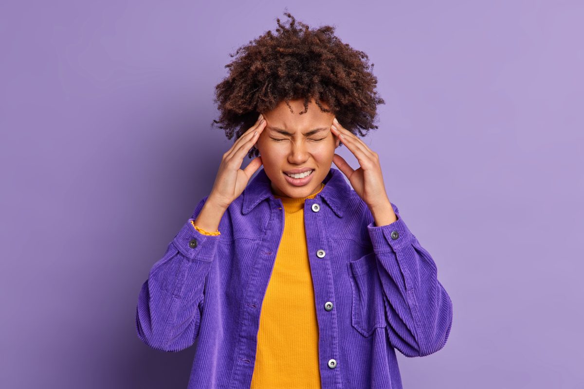 Woman touches her templates as if she has a headache or is stressed. Credit: Freepik.com