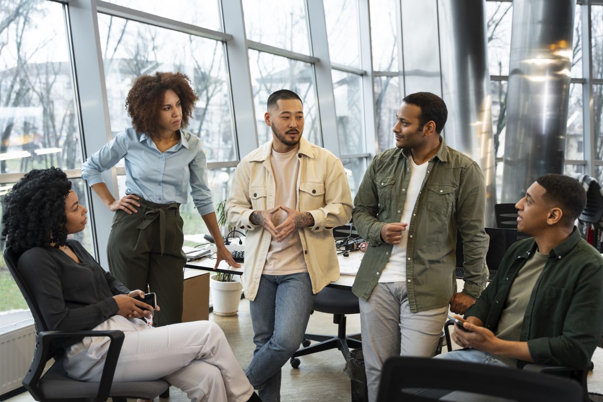 A team gathers around informally in the office. Image credit: Freepik.com